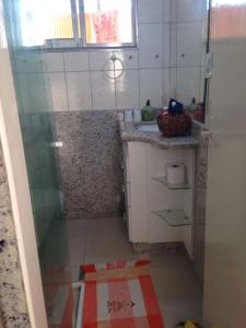 baño pequeño con ducha y lavamanos en Apartamento na Praia Grande, en Praia Grande