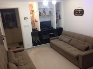 Una sala de estar con un sofá y un televisor. en Apartamento na Praia Grande, en Praia Grande