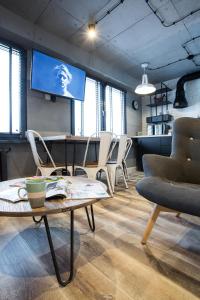 ウストシキ・ドルネにあるLoft Ustrzykiの椅子、テーブル、テレビが備わる客室です。