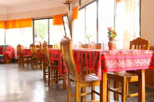 a dining room with a table and chairs and windows at Hotel Frontera in La Quiaca