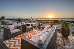 a woman sitting on a deck watching the sunset at The Beach House @ Grange in Grange