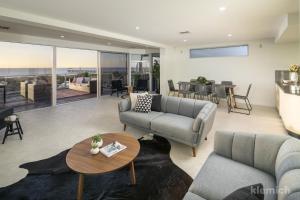 a living room with couches and a table at The Beach House @ Grange in Grange