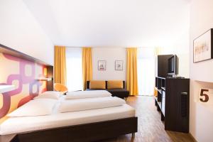 
a hotel room with two beds and a television at arte Hotel Krems in Krems an der Donau
