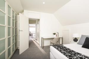 a bedroom with a bed and a desk and a table at The Beach House @ Grange in Grange