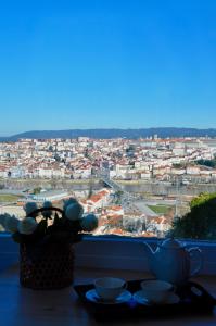 einen Tisch mit Stadtblick aus dem Fenster in der Unterkunft Confluentia H&A - Believe It or Not Apartments in Coimbra