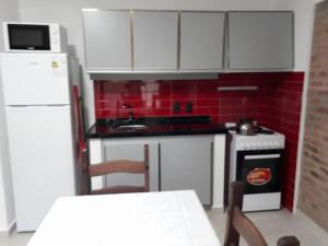 a small kitchen with white cabinets and red tiles at Los Cardenales in Santa Ana