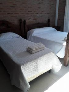 2 camas con toallas en un dormitorio en Los Cardenales, en Santa Ana