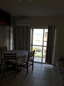 comedor con mesa, sillas y ventana en Cons das FLORES, en Florianópolis