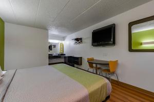 une chambre avec un lit, une table et une télévision dans l'établissement Days Inn by Wyndham Cincinnati I-71, à Cincinnati 9 autres photos