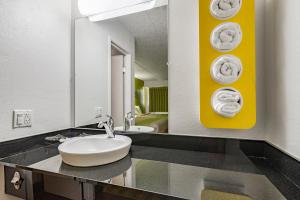 La salle de bains est pourvue d'un lavabo et de serviettes murales. dans l'établissement Days Inn by Wyndham Cincinnati I-71, à Cincinnati