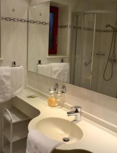 a bathroom with a sink and a mirror and a shower at Hotel garni Fuchs in Eichstätt
