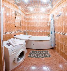 チュメニにある2кв Апартаменты на Пермякова 69/2のバスルーム(洗濯機、バスタブ付)