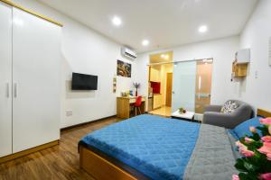 a bedroom with a blue bed and a living room at Sunrisehome in Ho Chi Minh City