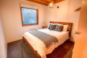 sypialnia z łóżkiem i oknem w obiekcie Drovers Rest w mieście Dinner Plain