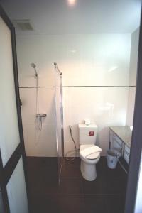 a bathroom with a toilet and a glass shower at TaamJai Resort in Nakhon Phanom