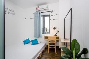 Piccola camera con letto e scrivania. di Fedora Hostel a Da Nang