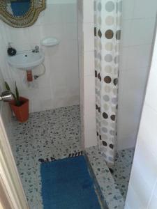 a bathroom with a shower curtain and a sink at Chelle's Guesthouse and Backpackers in Siquijor