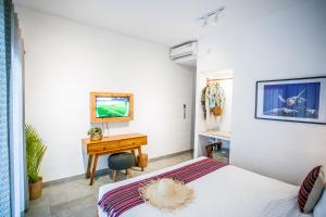 a bedroom with a desk and a bed and a table at Abdi Hotel in Gili Trawangan