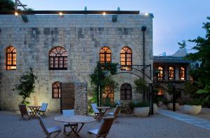 a stone building with tables and chairs in front of it at Alegra Boutique Hotel in Jerusalem