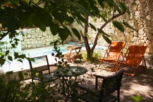eine Gruppe Stühle und ein Tisch neben einem Pool in der Unterkunft Alegra Boutique Hotel in Jerusalem