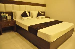 a bedroom with a large bed with white sheets and pillows at Lotus Grand Akm in Kālka