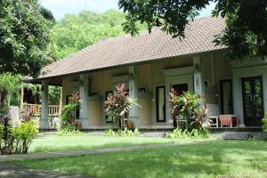 a house with a garden in front of it at Bali Gecko Homestay in Pemuteran