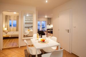 a dining room and living room with a white table and chairs at Haas Apartments Stojanova with Parking in Brno