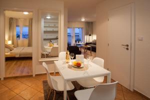 una sala da pranzo e un soggiorno con tavolo e sedie bianchi di Haas Apartments Stojanova with Parking a Brno