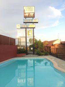 una piscina en un hotel con un cartel en Riverview Motor Inn, en Taree