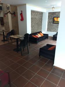 sala de estar con sofás, mesa y sillas en Hotel Residencial España en Salta
