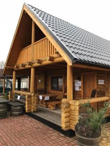 a log cabin with a dog laying on the deck at Wellness Hütte am Zwenkauer See bei Leipzig in Zwenkau