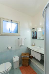 a bathroom with a toilet and a sink and a mirror at Case Spazioscena - Polimnia in Castelbuono