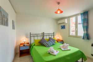 a bedroom with a green bed with two towels on it at Case Spazioscena - Polimnia in Castelbuono