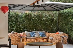 un patio con divano, sedie e ombrellone di Shenkin Hotel a Tel Aviv