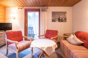 a living room with two chairs and a tv at Gästehaus Tannegg in Mittelberg