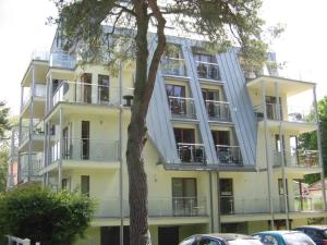 斯维诺乌伊希切Apartament Rezydencja Bursztyn的一座黄色的大建筑,前面有汽车停放