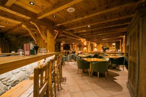 ein Restaurant mit Holzdecken, Tischen und Stühlen in der Unterkunft Hotel Xalet Montana in Soldeu