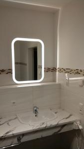 ein weißes Badezimmer mit einem Waschbecken und einem Spiegel in der Unterkunft Blue River Side in Blaustein