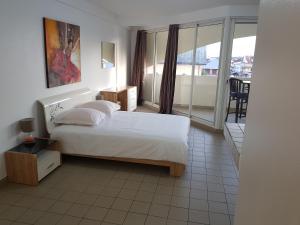 1 dormitorio con 1 cama y balcón en Hello Guyane 1 - Appartement de Luxe, 5 étoiles, en Cayenne