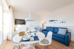 a living room with a blue couch and a table and chairs at Min Hüsung by Rujana in Binz