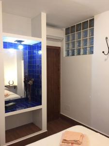 uma casa de banho com um chuveiro com azulejos de vidro azul em Apartamentos Manbea Algaida em San José