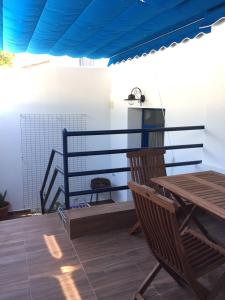 un patio con una mesa de madera y un techo azul en Apartamentos Manbea Algaida, en San José