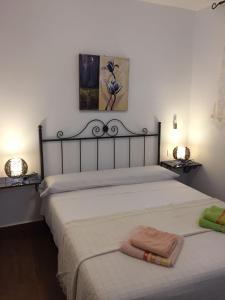 1 dormitorio con 1 cama blanca grande y 2 toallas en Apartamentos Manbea Algaida, en San José