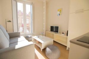 a white living room with a couch and a tv at Opera Apartments - Alameda in Seville