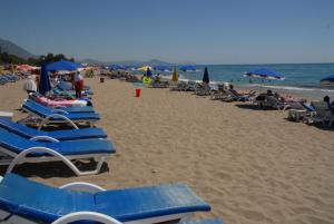 Un montón de sillas y sombrillas en una playa en Merhaba Hotel, en Alanya