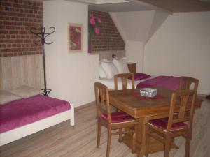 Habitación con mesa, sillas y cama en B&B Pottebreker, en Vlamertinge