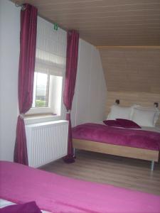 a bedroom with a bed with red curtains and a window at B&B Pottebreker in Vlamertinge