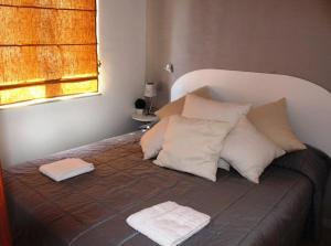 a bed with pillows and two towels on it at Rais Gerbi Appartamento in Pollina