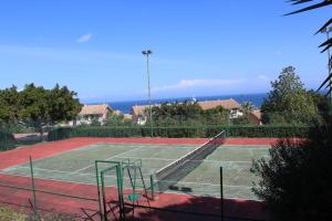 a tennis court with the ocean in the background at Rais Gerbi Appartamento in Pollina