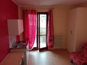 a kitchen with red curtains and a door with a balcony at B&B Casa Murgiana in Gravina in Puglia
